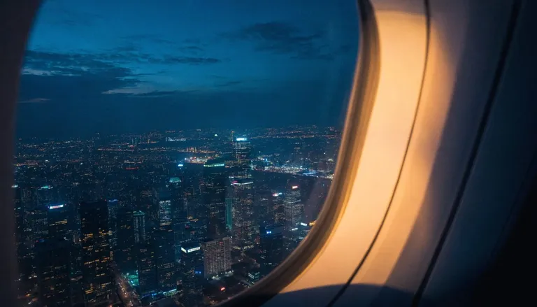 View from an airplane window over a glittering Asian city at night