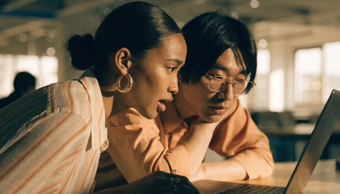 Two people collaborating over a laptop in a Tokyo workspace